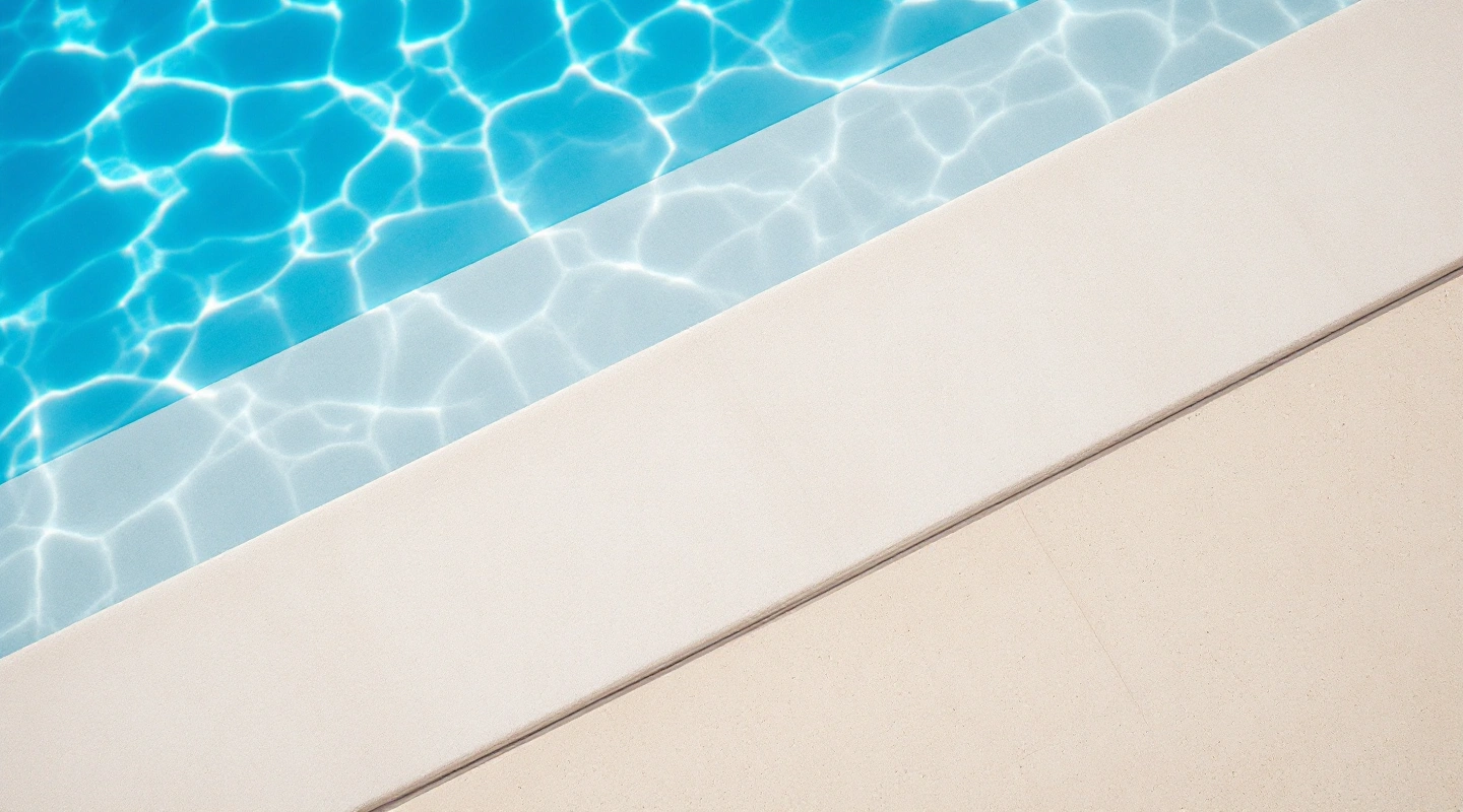 Clear pool water beside pale stone coping